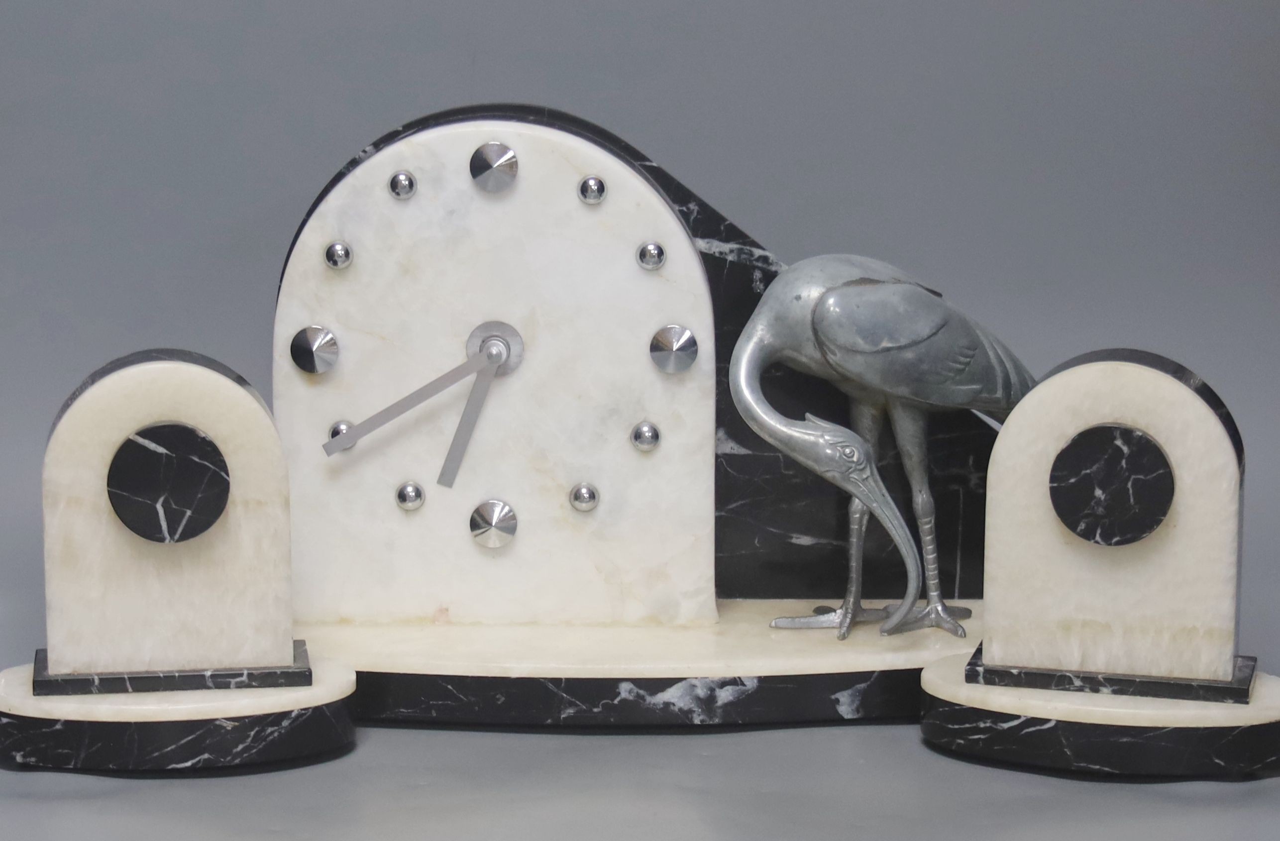 An Art Deco clock garniture, with stork surmount, clock width 41cm (modified quartz movement)